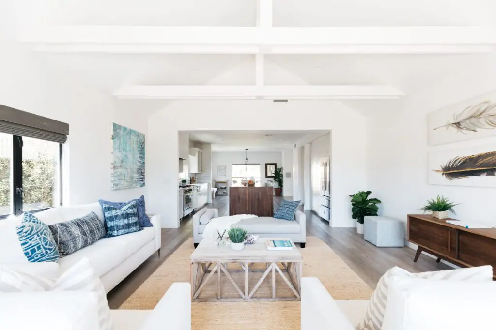 a living room with white sofa and chairs